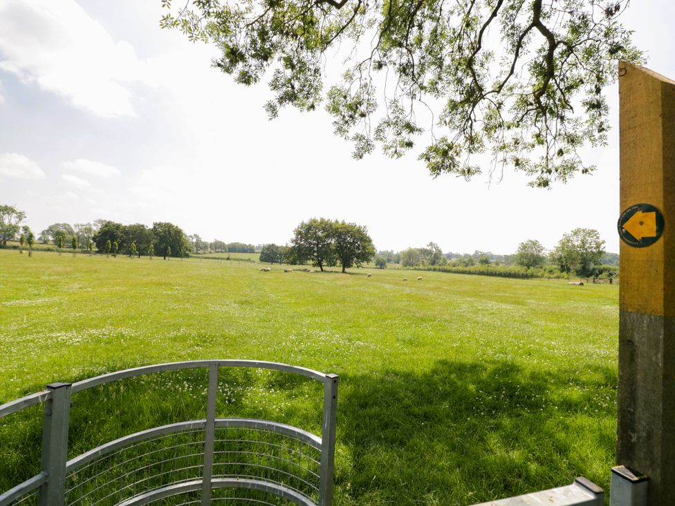 A landscape with a gate and trees at The Stable Flat 