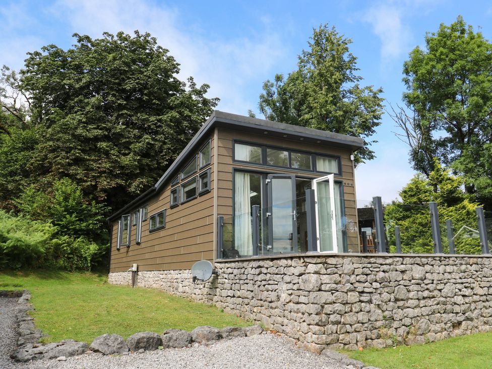 A house with large windows and a stone wall at Dales Retreat Threshfield near Grassington