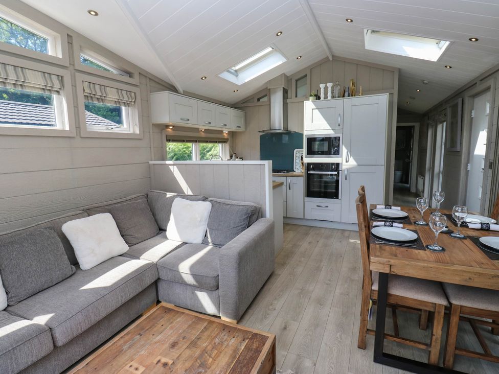 A living room and kitchen area with sofa and dining table at Dales Retreat Threshfield near Grassington