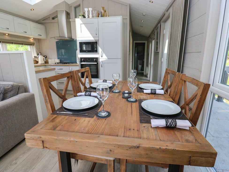 A dining area with a wooden table set for dinner at Dales Retreat Threshfield near Grassington