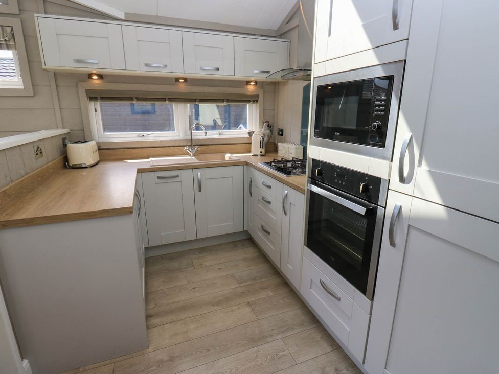 A kitchen with cabinets and appliances at Dales Retreat Threshfield near Grassington