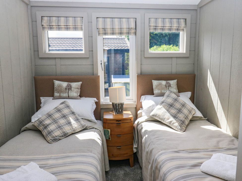 A bedroom with two beds and a side table at Dales Retreat in Threshfield near Grassington