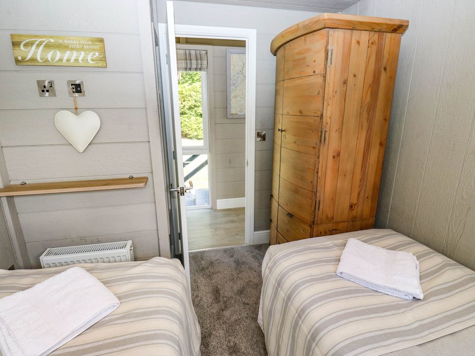 A bedroom with two beds and a wardrobe at Dales Retreat Threshfield near Grassington