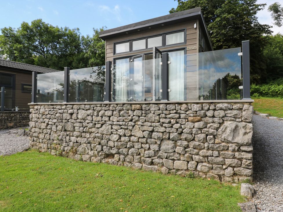 A building with glass railings and a stone wall at Dales Retreat in Threshfield near Grassington