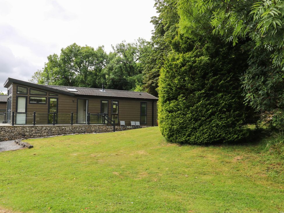 A building surrounded by grass and trees at Dales Retreat in Threshfield near Grassington
