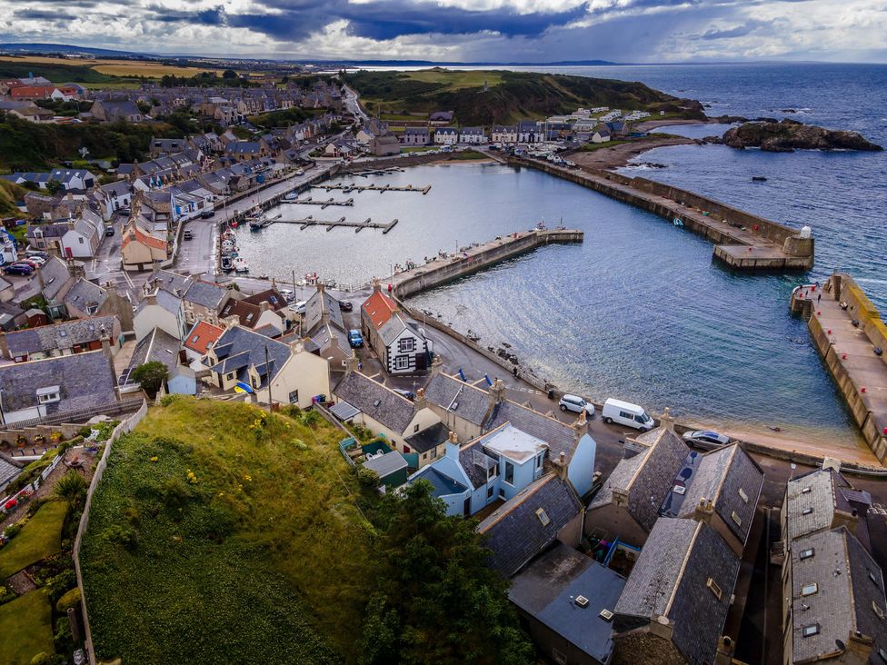 An aerial view of a harbor with boats and houses near the water at a coastal location
