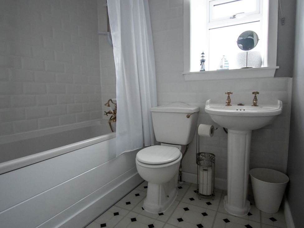 A bathroom with a bathtub, toilet, and sink at the property