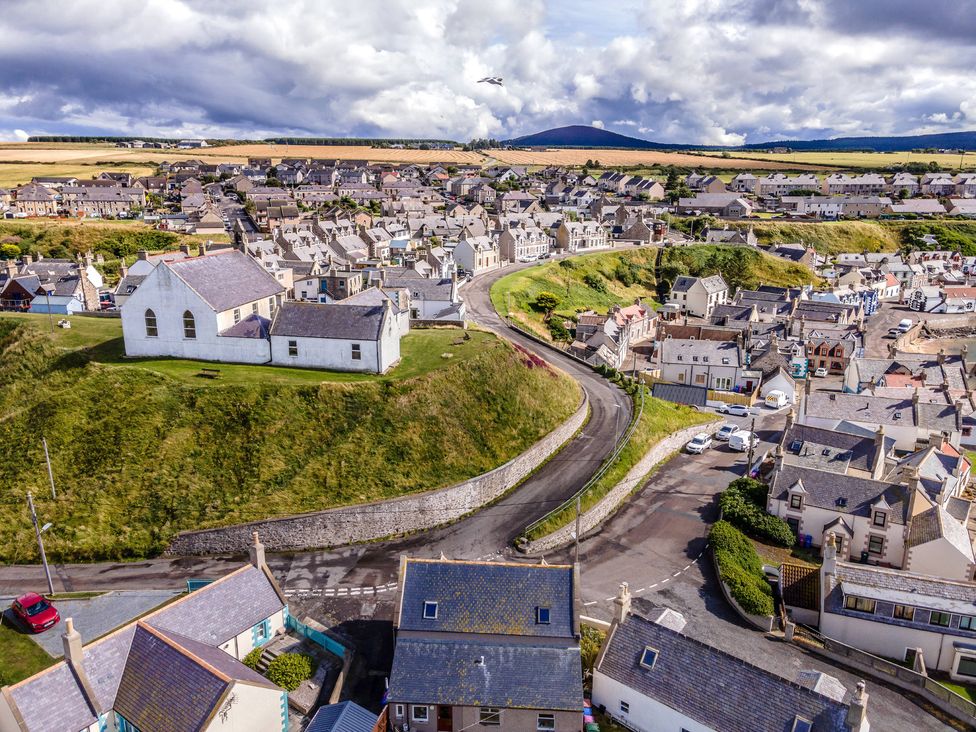 An aerial view of a village with houses and a church on a hill