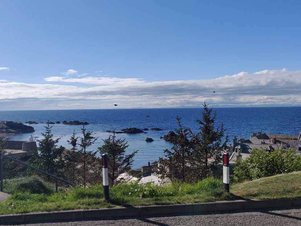 A view of the sea with rocks and trees at a coastal location