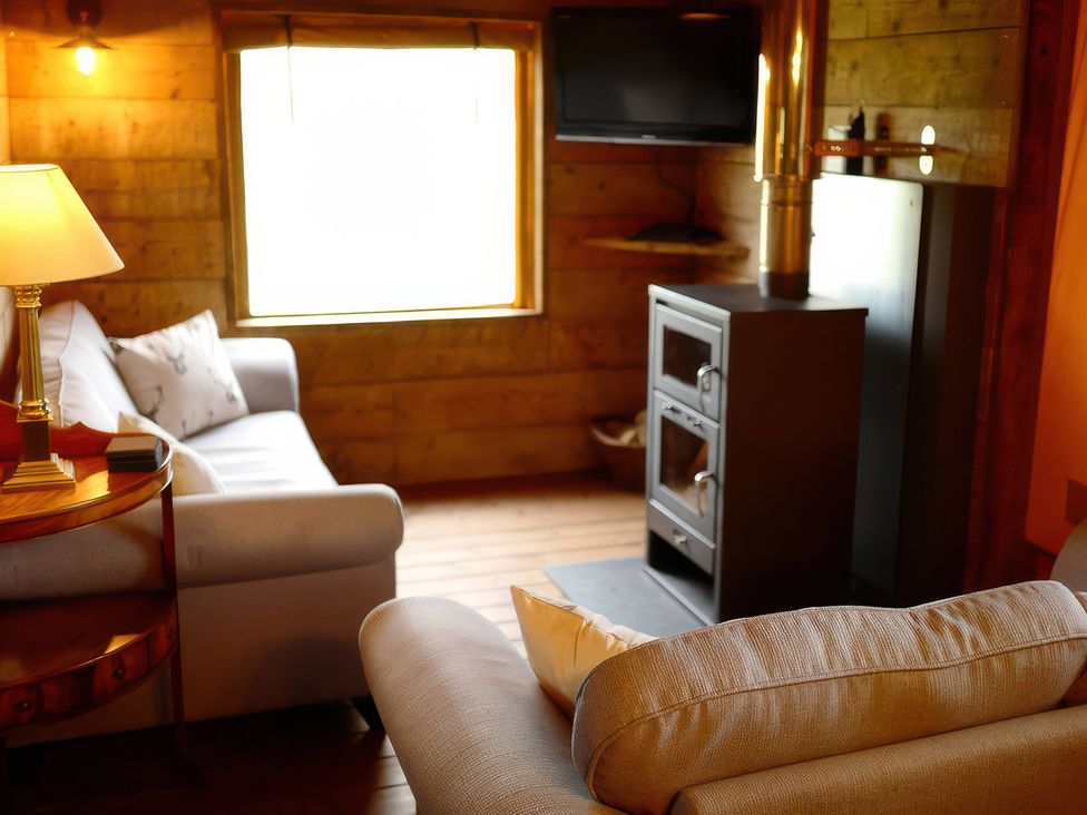 A living room with a couch and wooden stove
