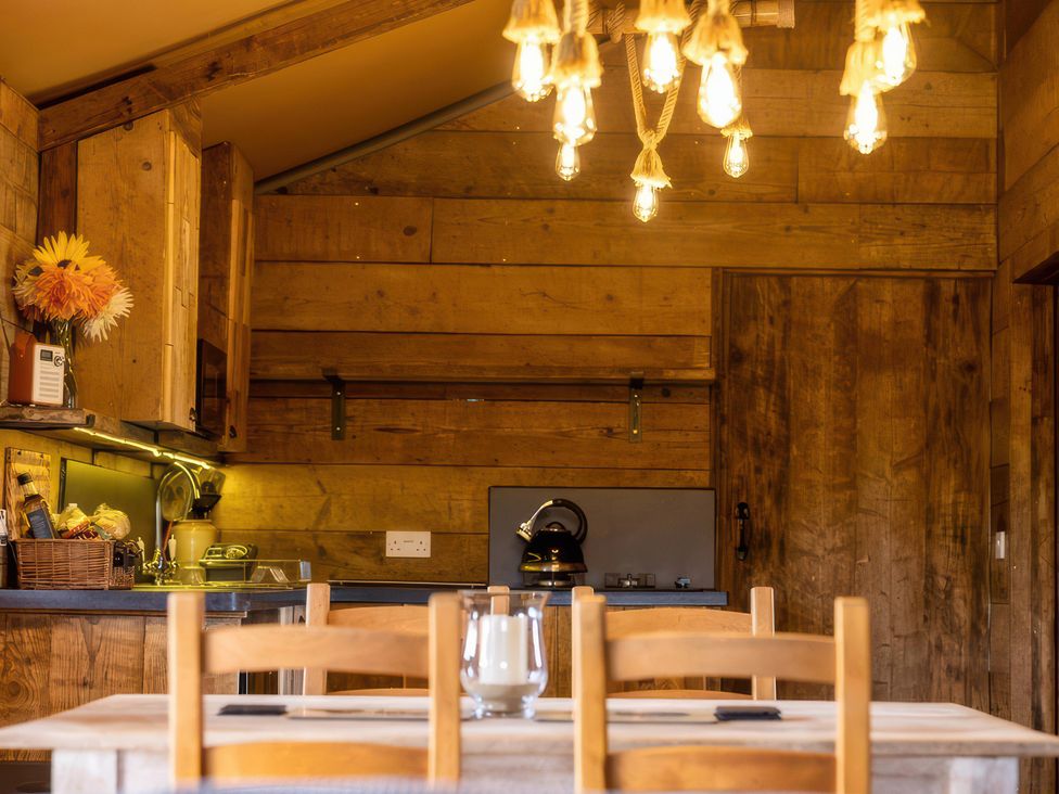 A kitchen with wooden cabinets and a table at The Old Barn in Manchester