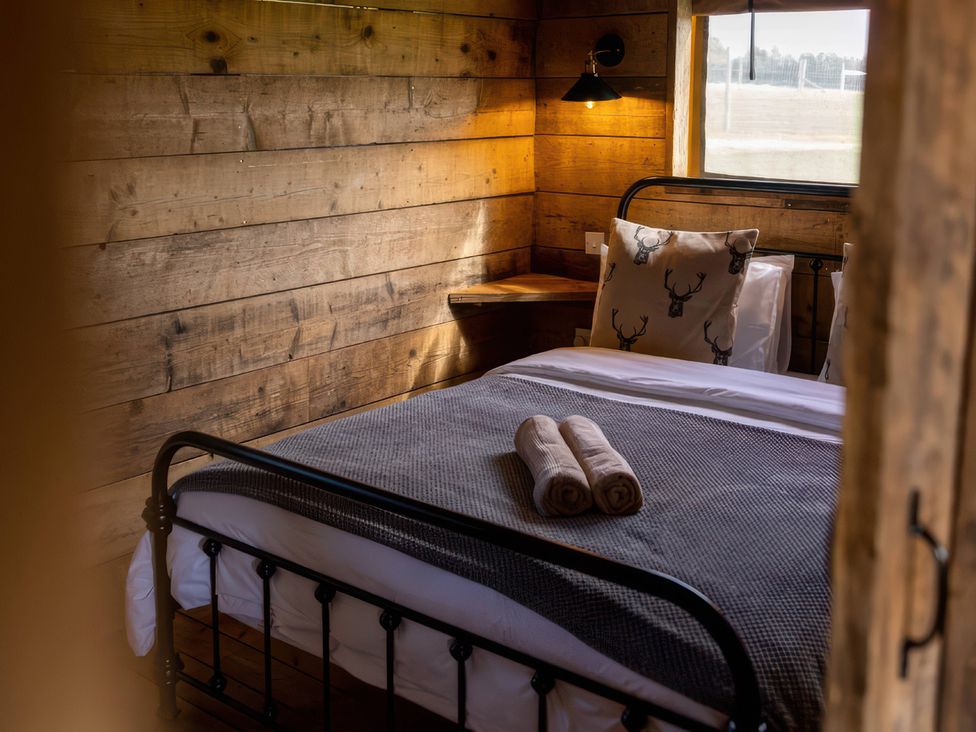 A bedroom with a bed and a bedside table at The Cabin in the Woods
