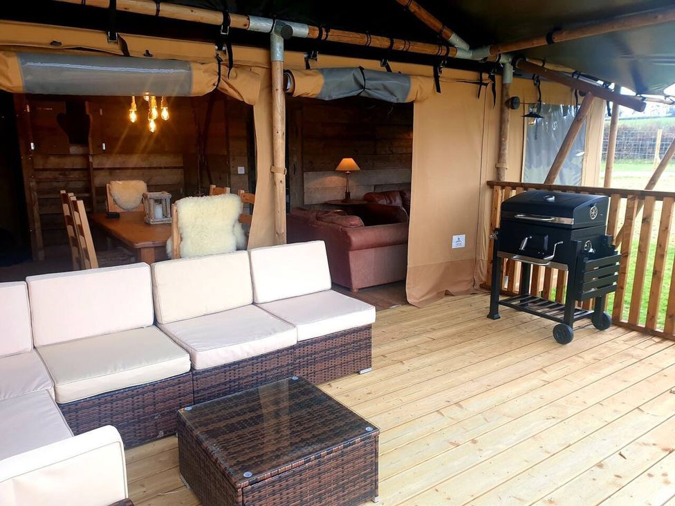 An outdoor living area with seating and a grill at a property
