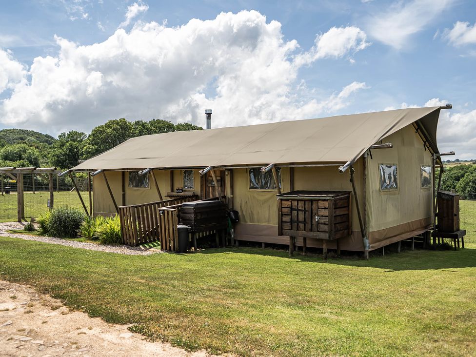 A tent with wooden platform and outdoor seating at Luxury Safari Lodge Sleeps 4/6 Deer Park Dogs Ok Zeal Monachorum near Bow