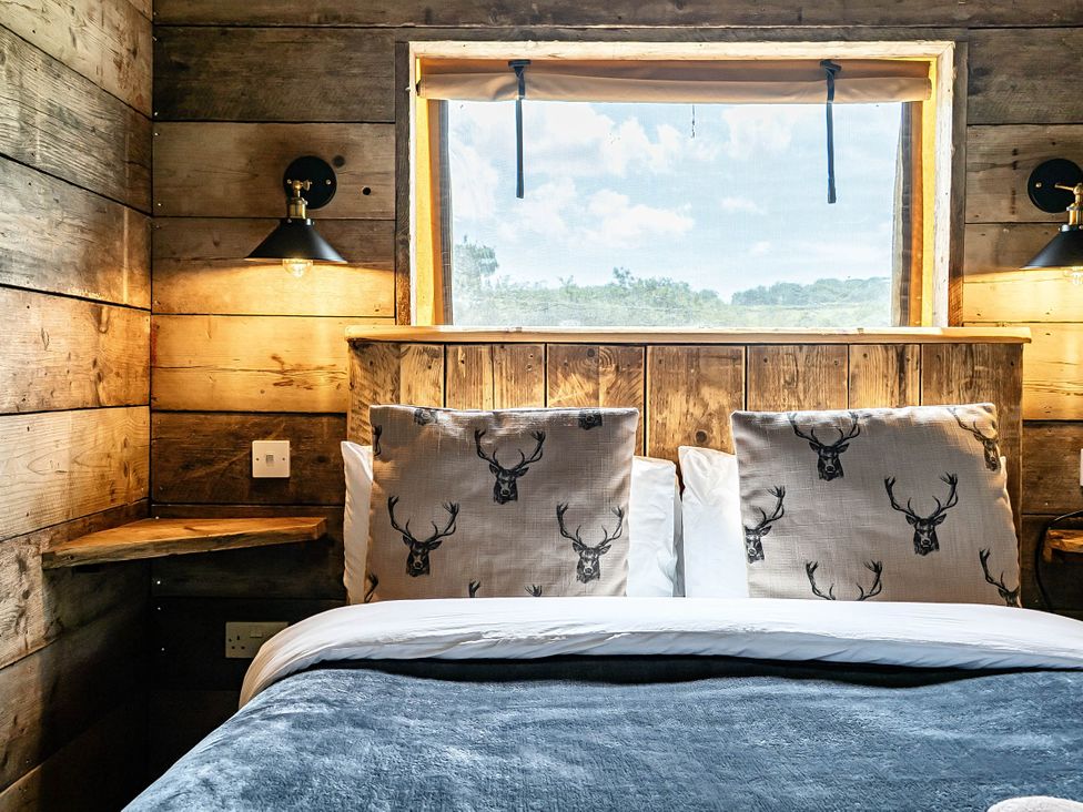 A bedroom with a bed and pillows at Luxury Safari Lodge Sleeps 4/6 Deer Park Dogs Ok Zeal Monachorum near Bow