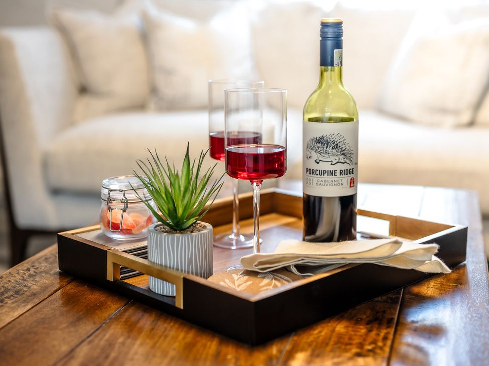 A tray with glasses and a wine bottle on a table in a living room