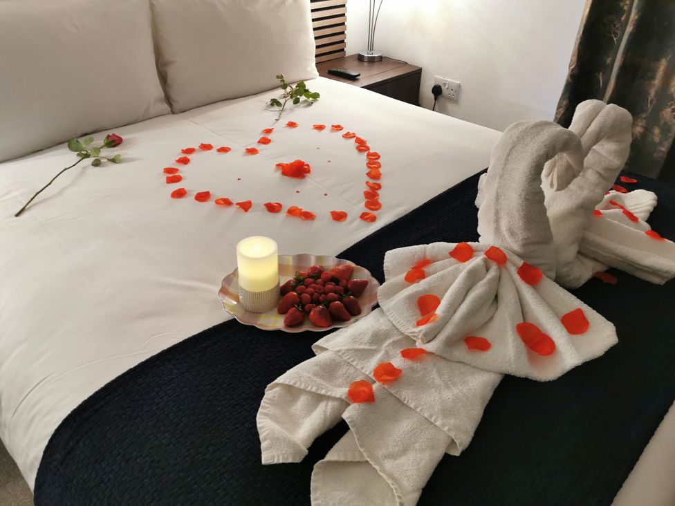A bedroom with a heart shape made of rose petals on a bed at the property