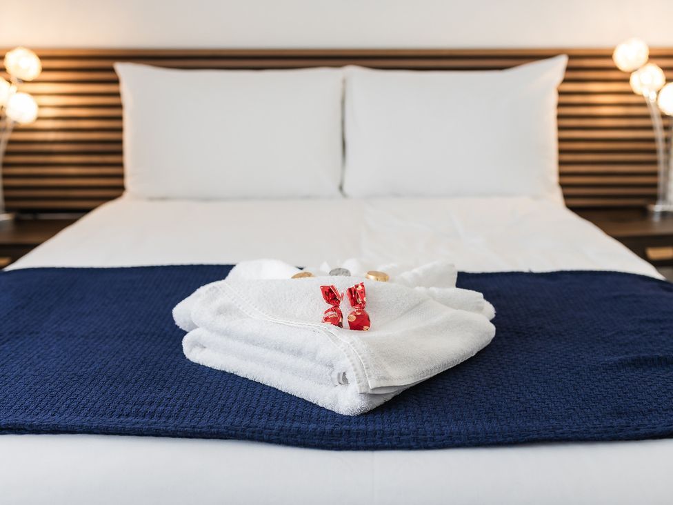 A bed with towels and pillows at a hotel