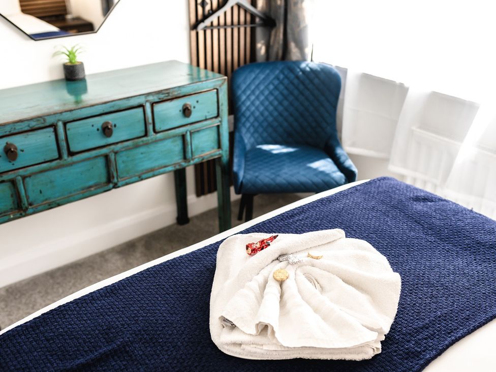 A towel on a bed with a console table and chair at the property