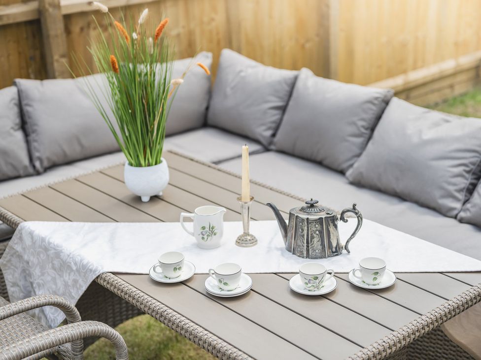 An outdoor seating area with a table set for tea at 