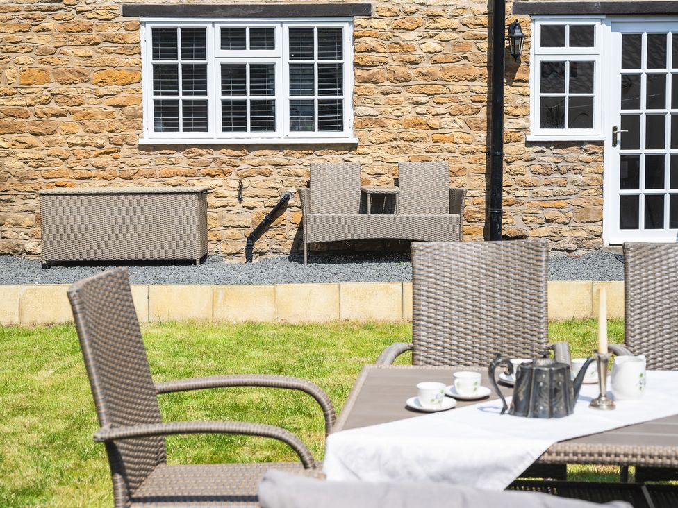 A garden with a dining set and decorative items at the property'' in ''