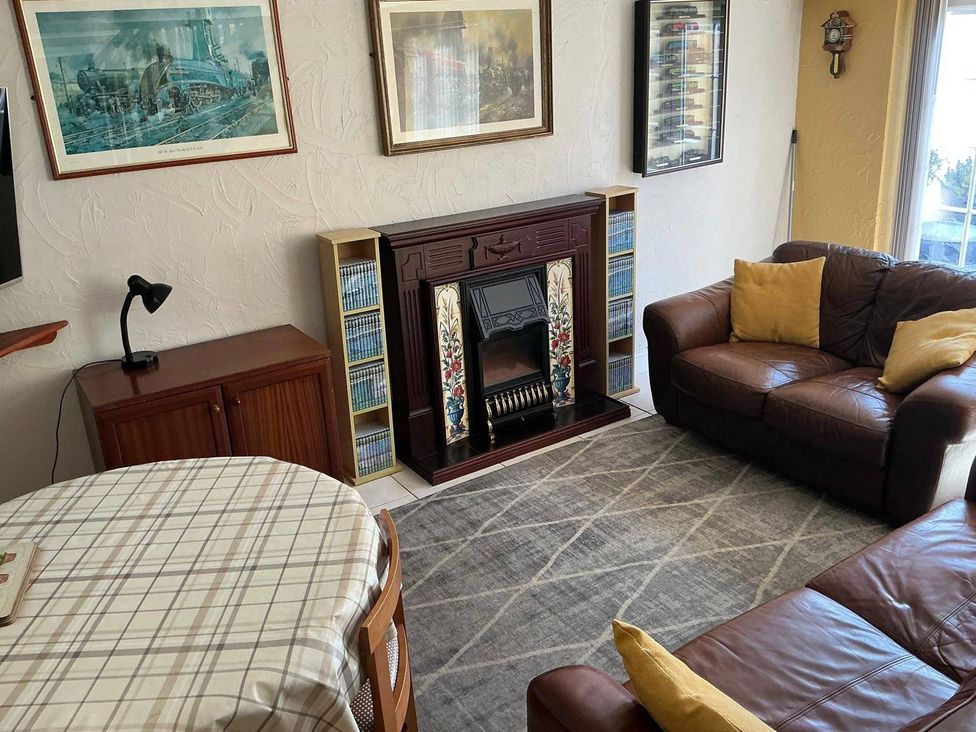 A living room with a fireplace, sofa, and coffee table at The Old Barn in Manchester
