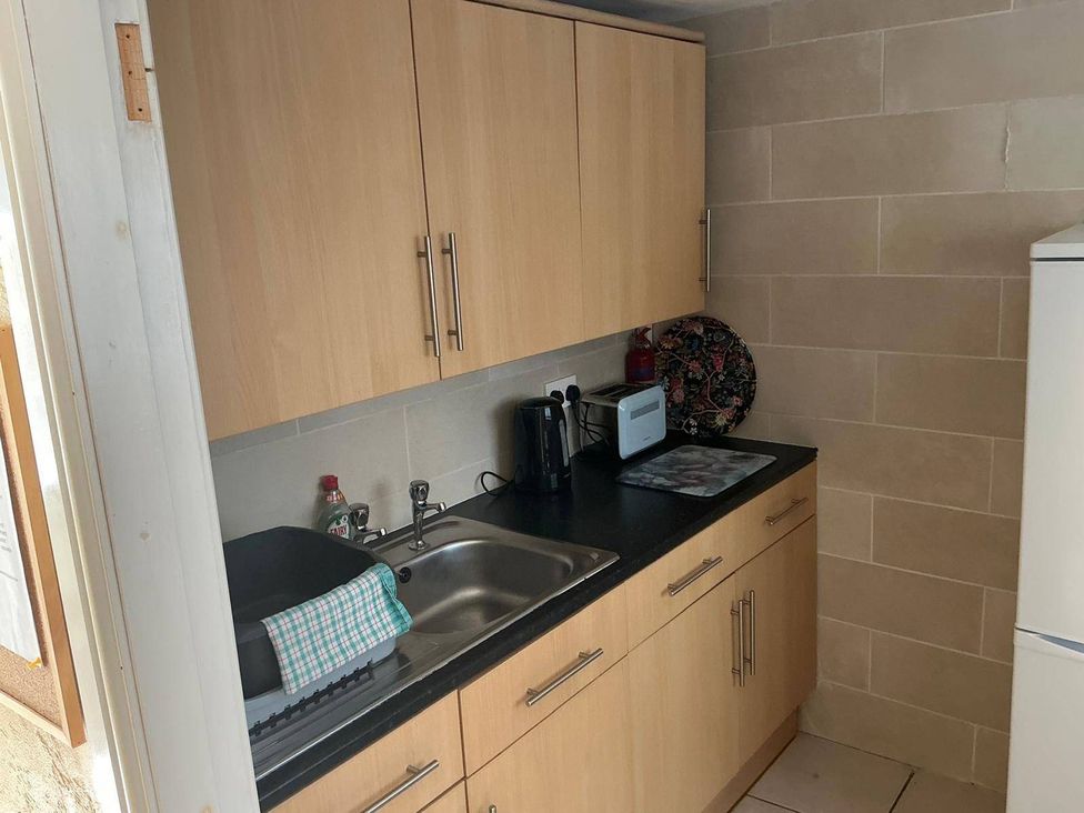 A kitchen with cabinets and sink at The Old Barn in Manchester