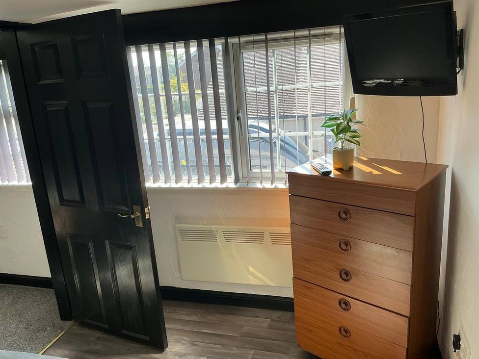 A bedroom with a television and a chest of drawers at The Old Barn in Manchester
