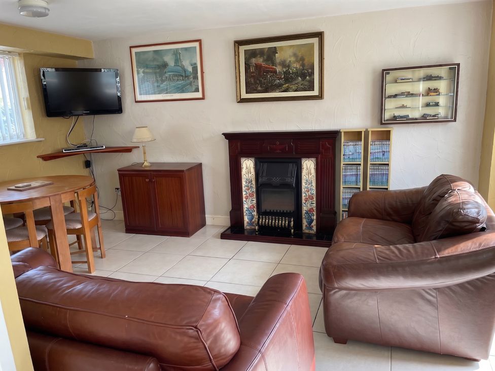 A living room with a television and fireplace at The Old Barn in Manchester