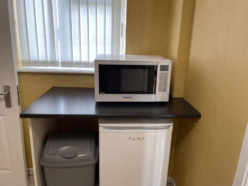 A kitchen with a microwave and refrigerator on a countertop
