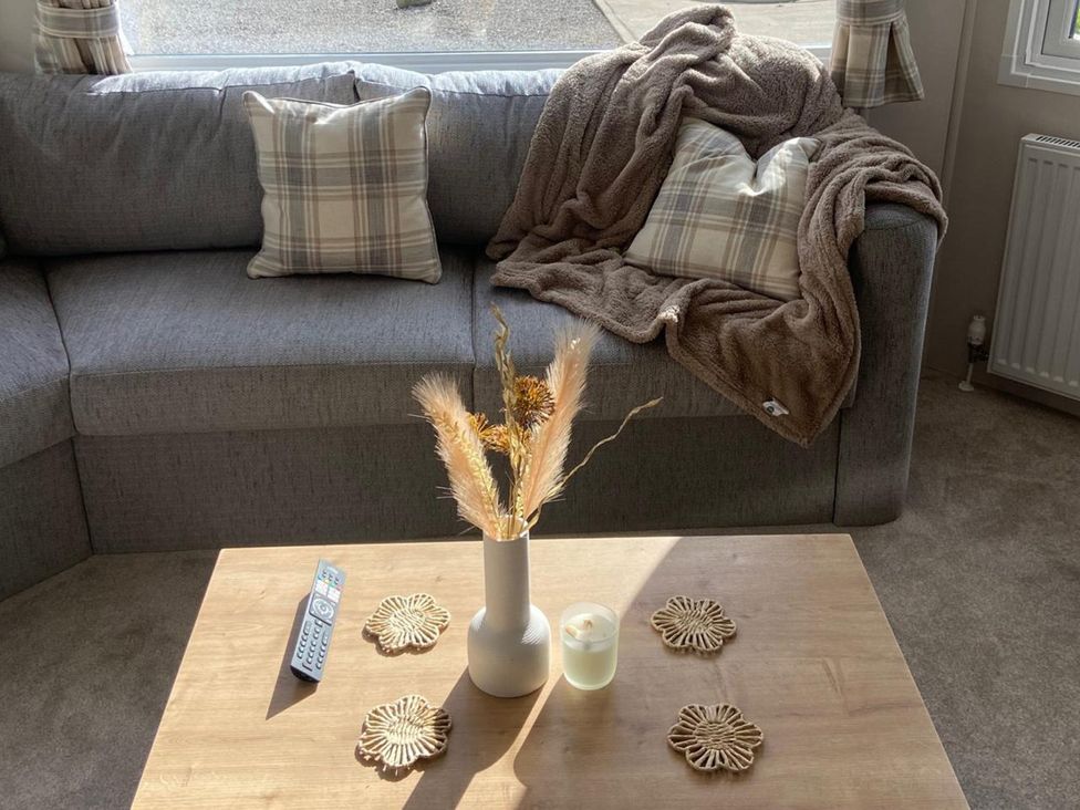 A living room with a sofa, table, and decorative items at the property