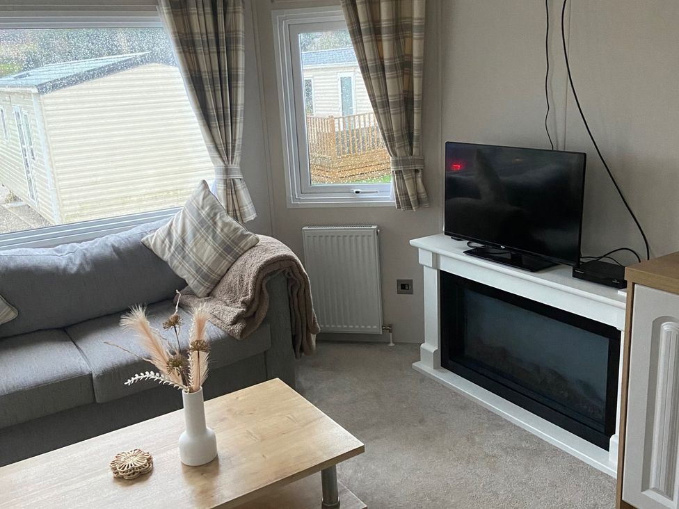 A living room with a sofa, coffee table, and television at the property in an unspecified location