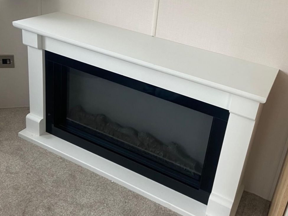 A fireplace with a white mantle in a living room