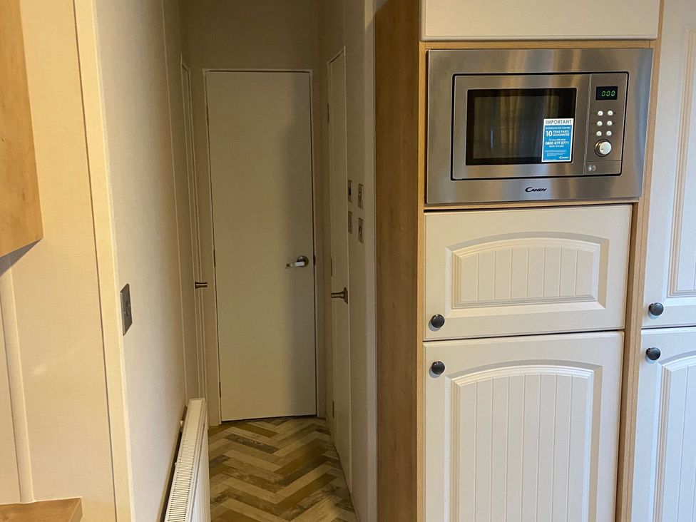 A kitchen with cabinets and a microwave at The Old Barn in Manchester