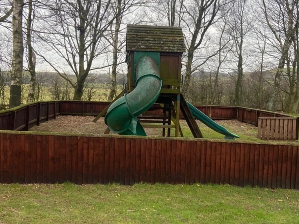 A playground structure with a slide in an outdoor area