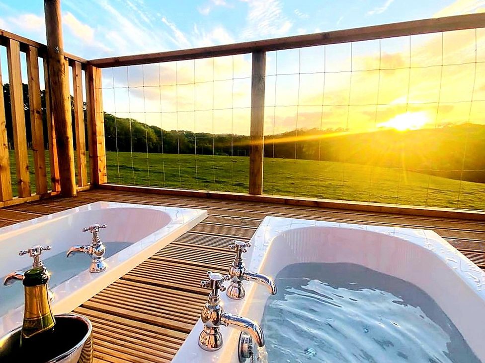 Two bathtubs on a wooden deck with a scenic view at a property