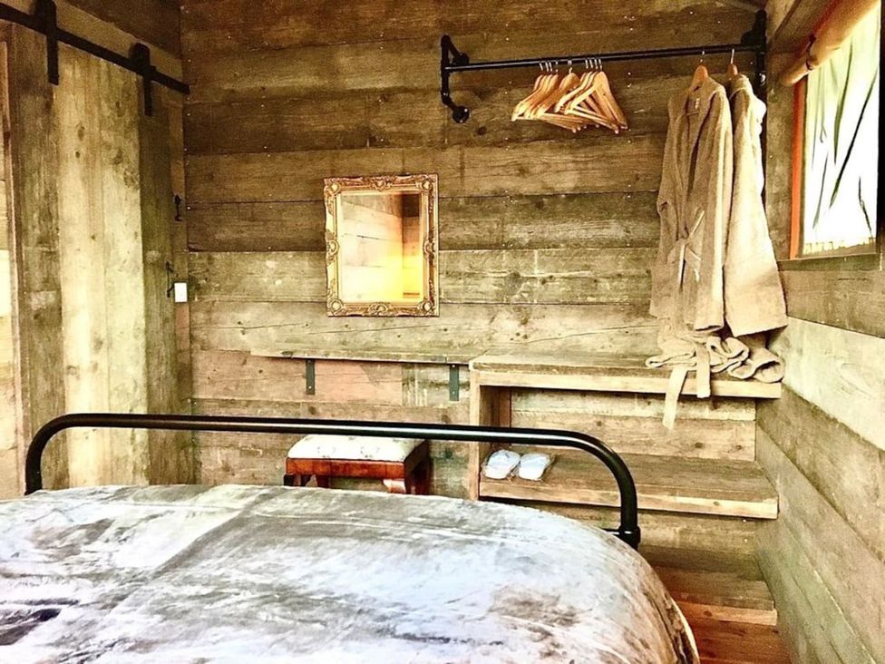 A bedroom with a bed and wooden shelves at The Old Barn in Manchester