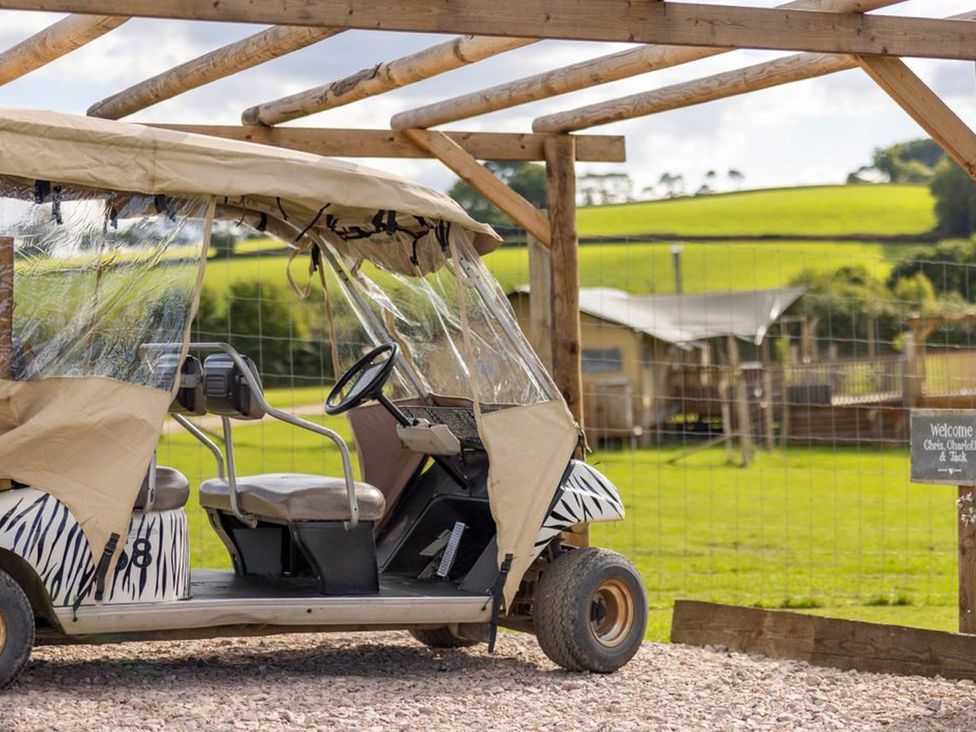 A golf cart under a canopy with a sign in an outdoor area at 