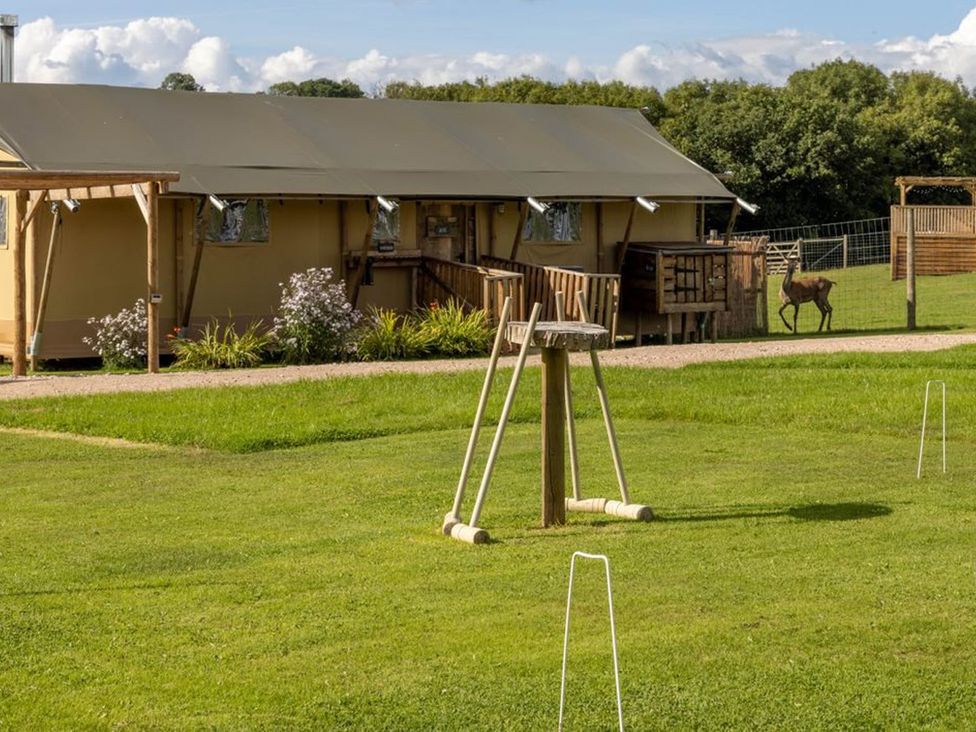 An outdoor area with a tent and deer at an unspecified location