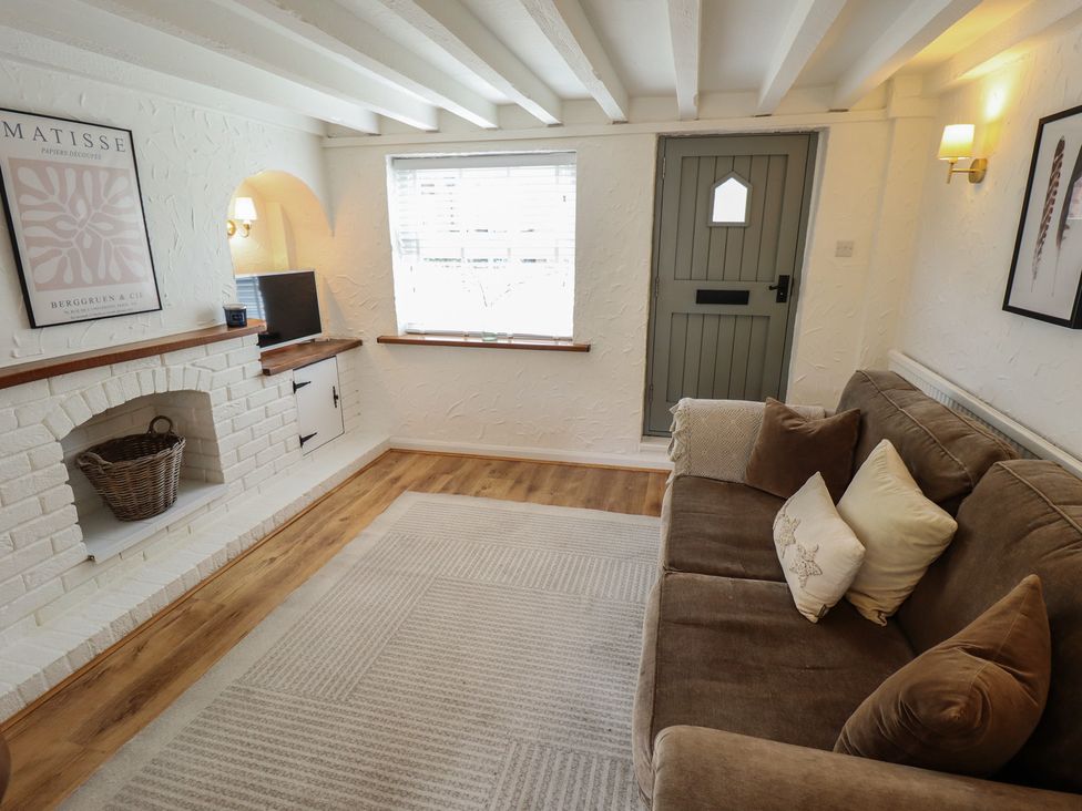 A living room with a couch and television at Pax Cottage