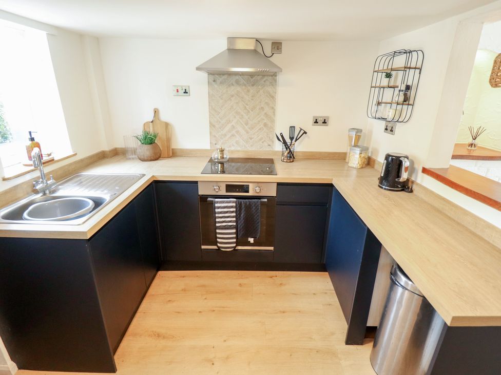 A kitchen with a sink, stove, and oven at Pax Cottage