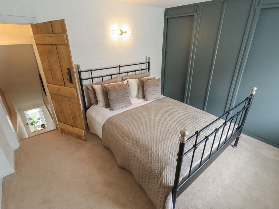 A bedroom with a bed and a wooden door at Pax Cottage