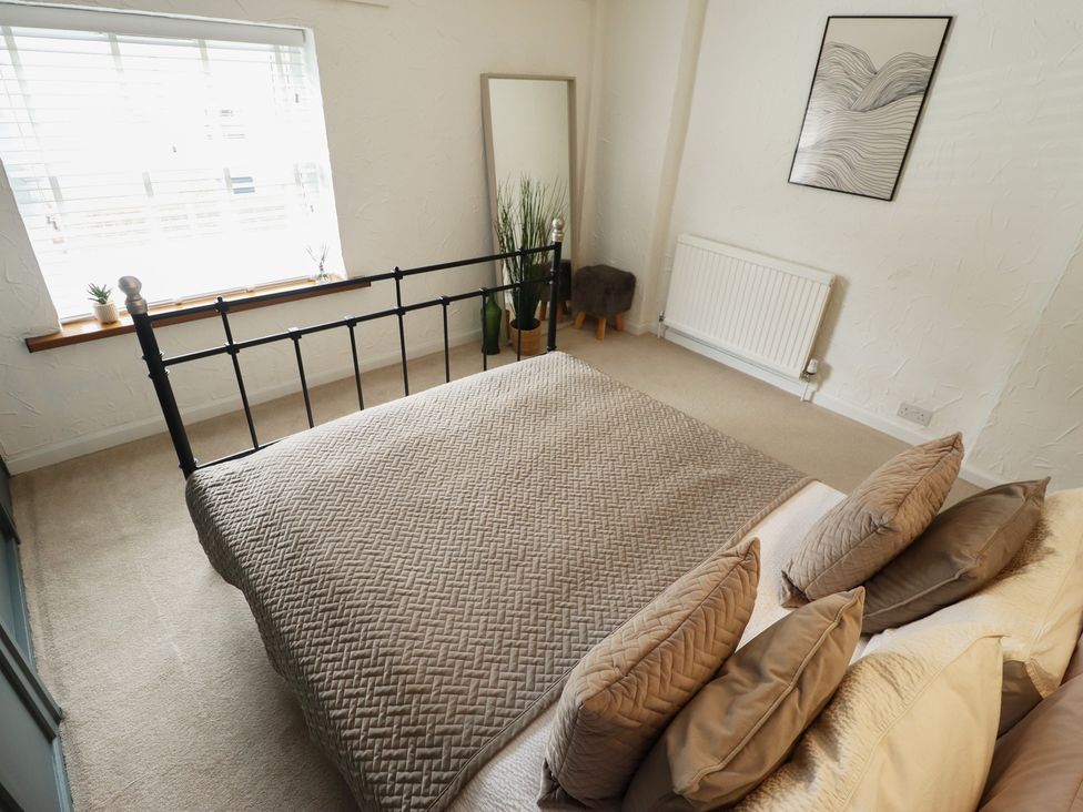 A bedroom with a bed, pillows, and a window at Pax Cottage