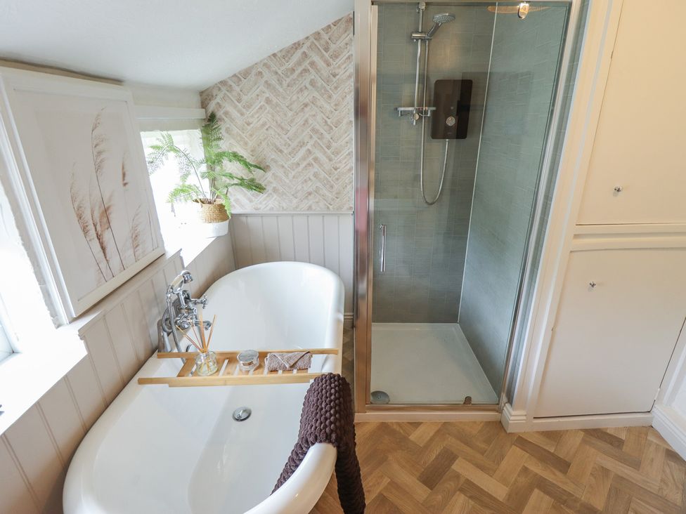 A bathroom with a bathtub and shower in Pax Cottage