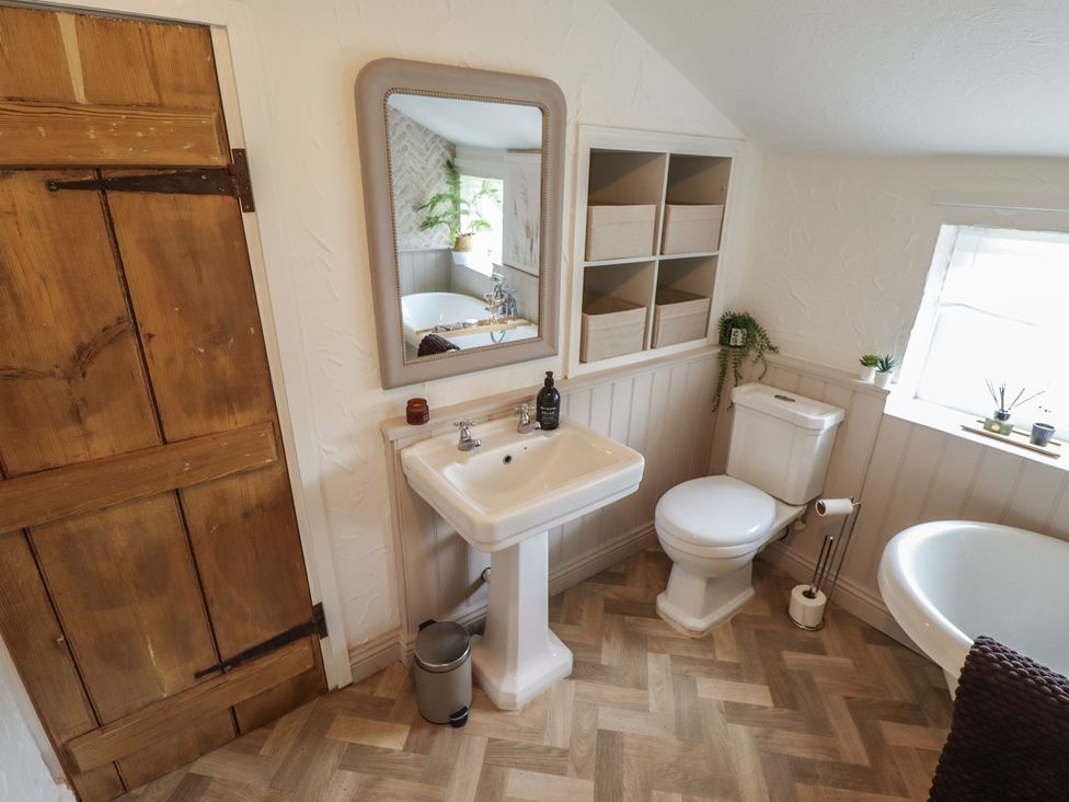 A bathroom with a sink, toilet, and bathtub at Pax Cottage