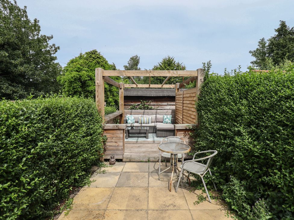 A garden with sofa and table at Pax Cottage