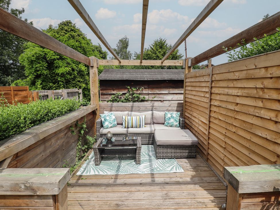 A garden seating area with a couch and coffee table at Pax Cottage