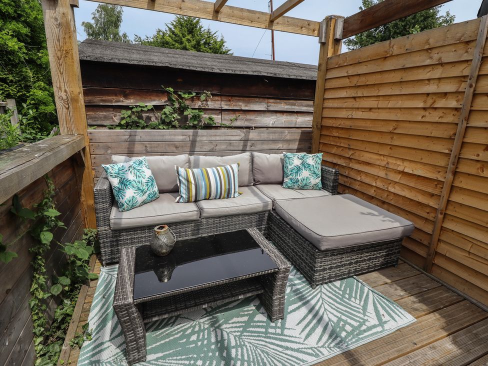 An outdoor seating area with a sofa and coffee table at Pax Cottage