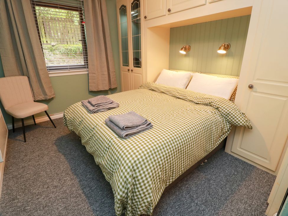 A bedroom with a double bed and a chair at No.31 Craigard Road
