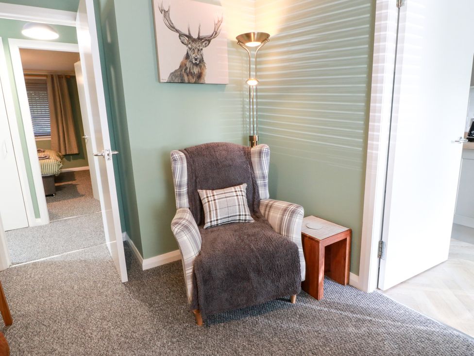 A living room with an armchair and side table at No.31 Craigard Road